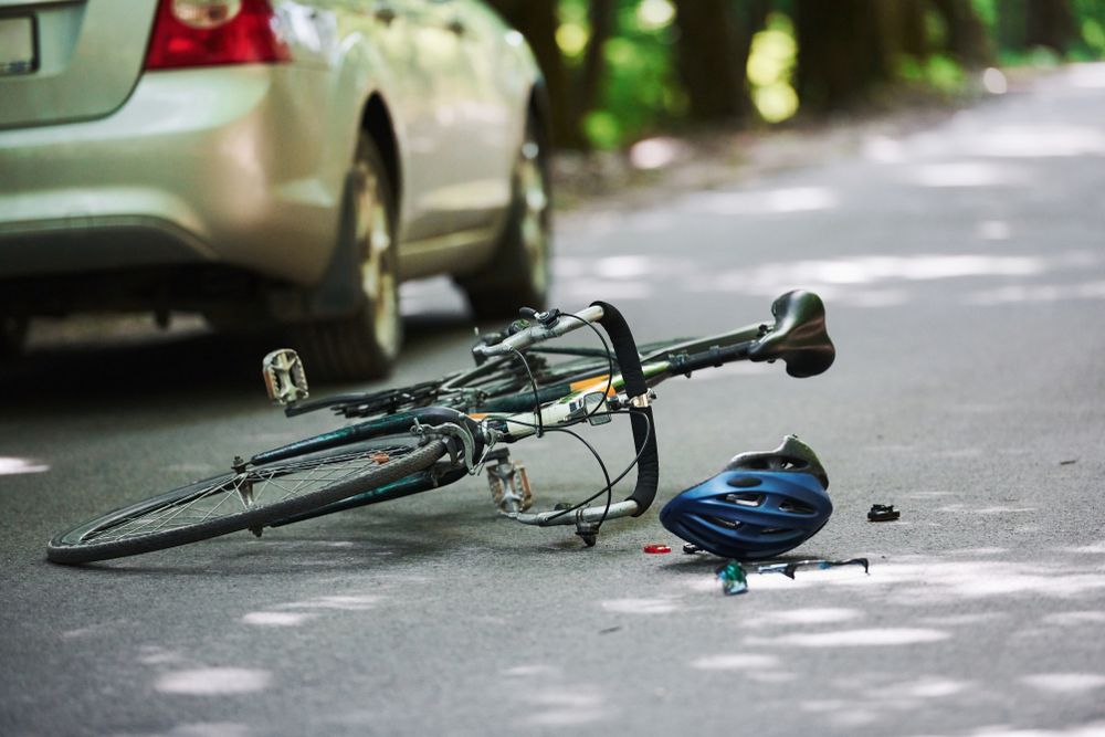 Bicycle and helmet on roadway after crash showing why to contact a Dallas Bicycle Accident Lawyer