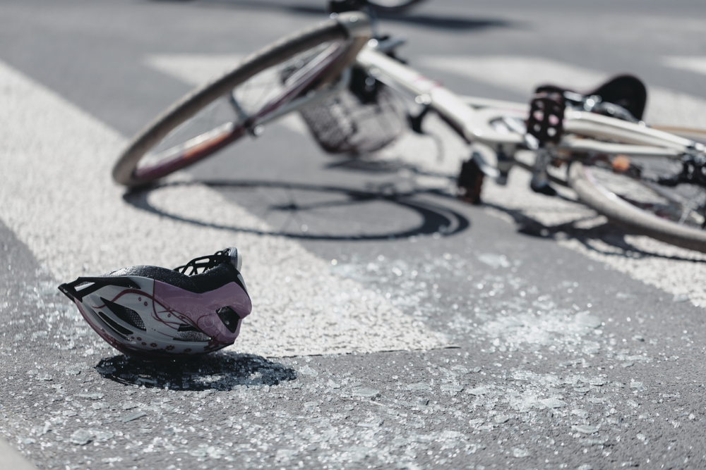 Broken bicycle and helmet on roadway showing need for a Dallas Bicycle Accident Lawyer