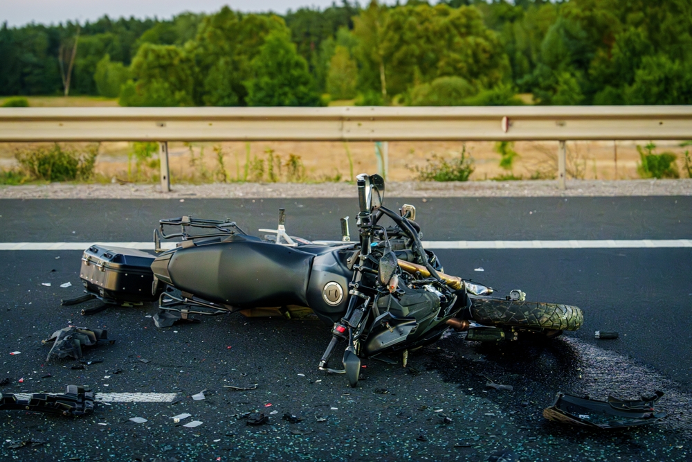 Damaged motorcycle on roadway after crash requiring a Dallas motorcycle accident lawyer
