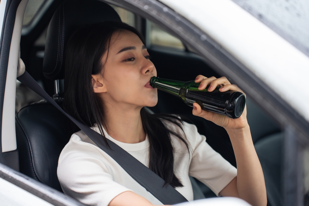 Dallas drunk driving accident lawyer image of driver drinking alcohol inside car