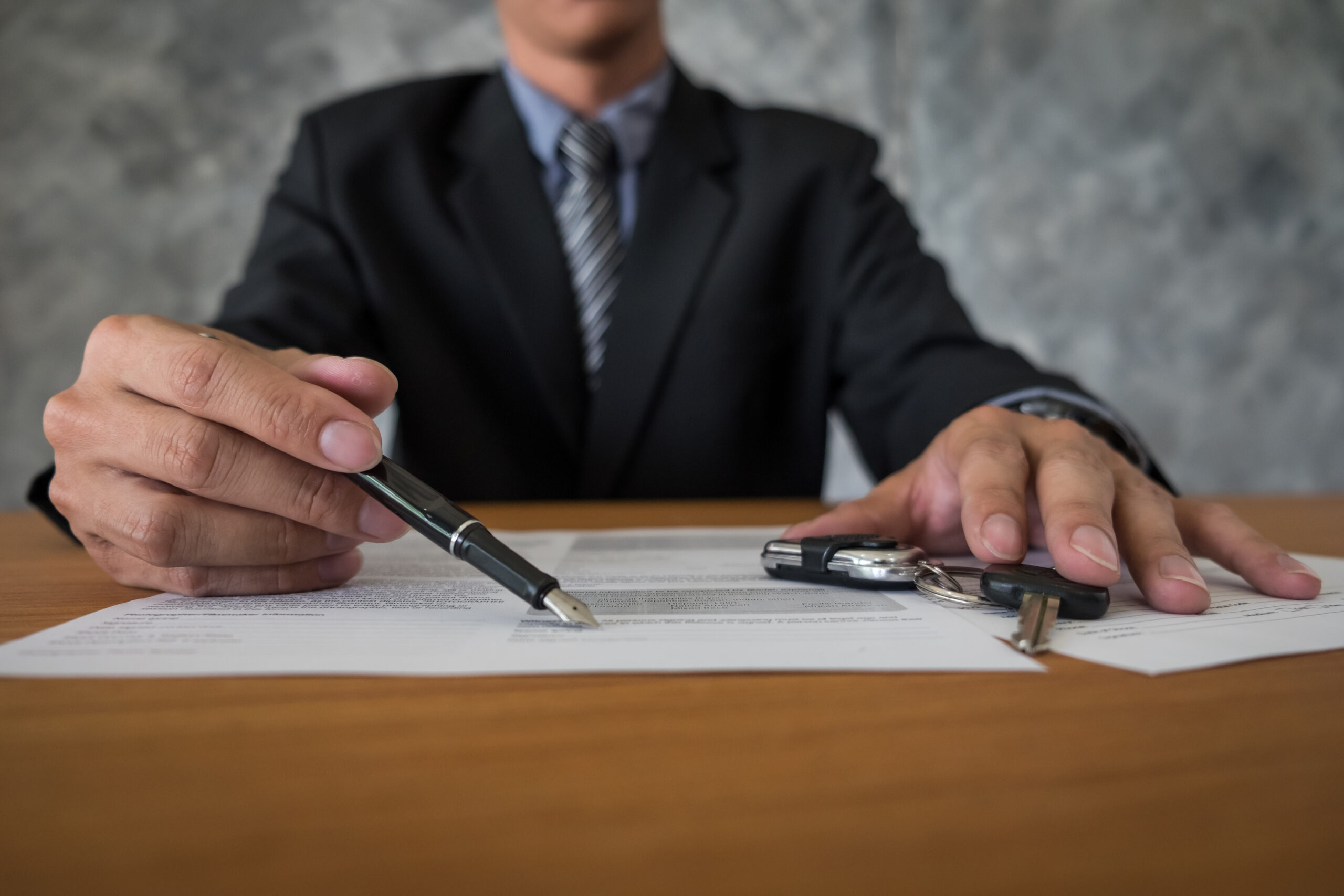 Client signing legal agreement with keys on table in Fort Worth related to premises liability case